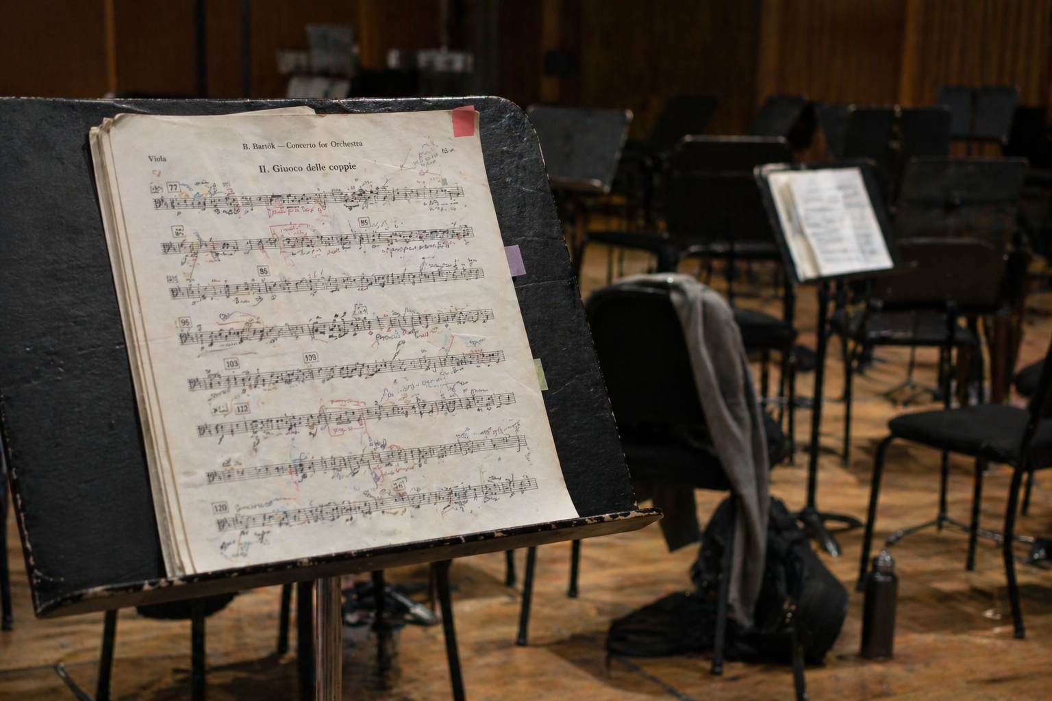 Marked-up orchestral part on a music stand in an empty rehearsal room
