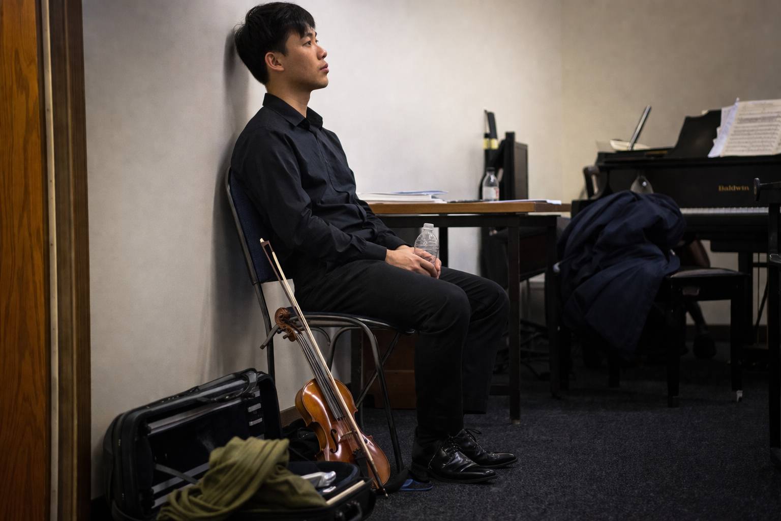 Musician sitting quietly in a warm-up room after playing, lost in thought Musician sitting quietly in a warm-up room after playing, lost in thought