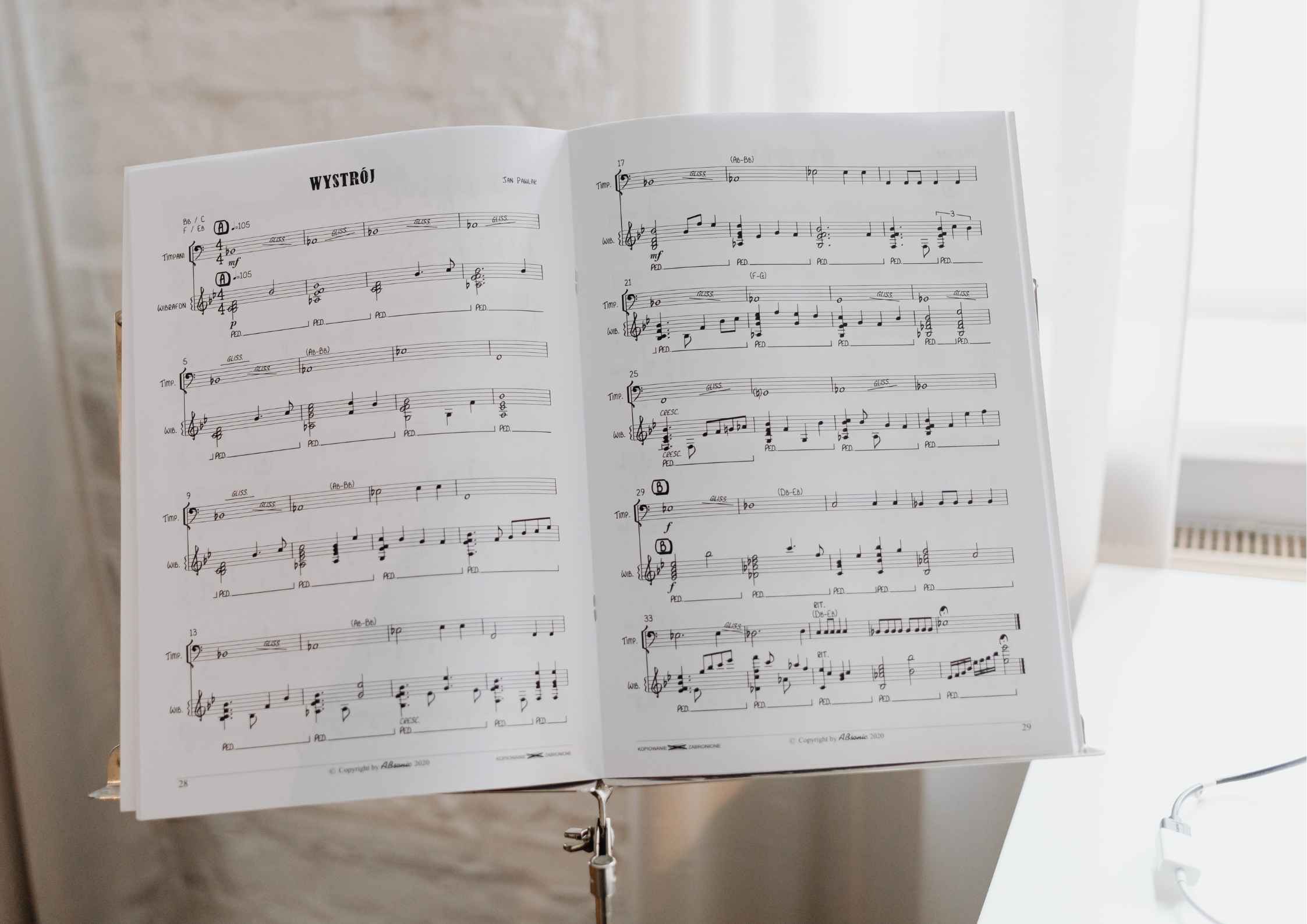 Marked viola orchestral part open on a music stand in an empty rehearsal room