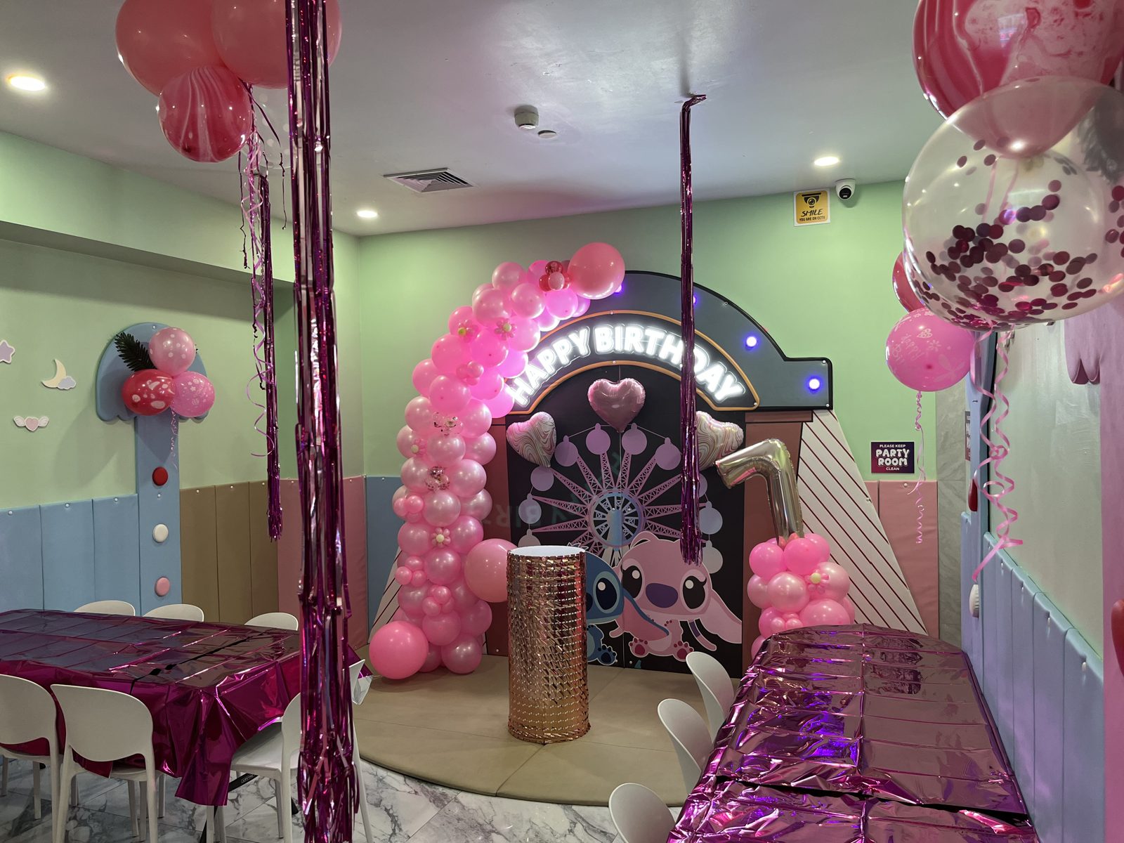 Birthday party area with a balloon arch