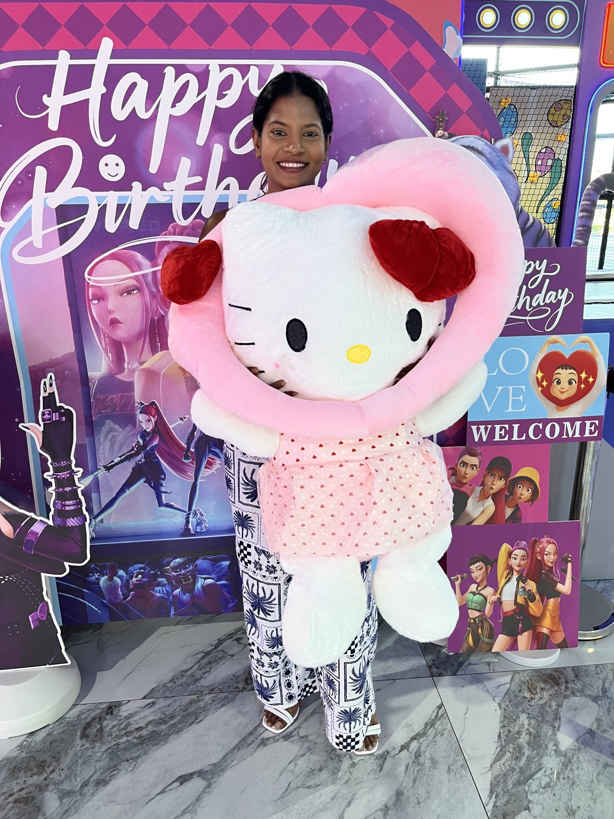 Costumed mascot at a birthday welcome backdrop