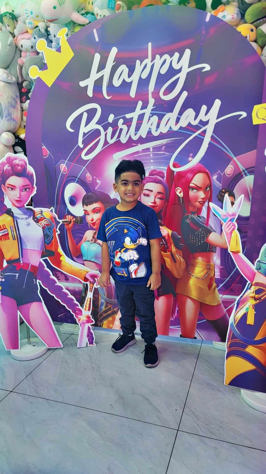 Boy posing at a birthday photo backdrop