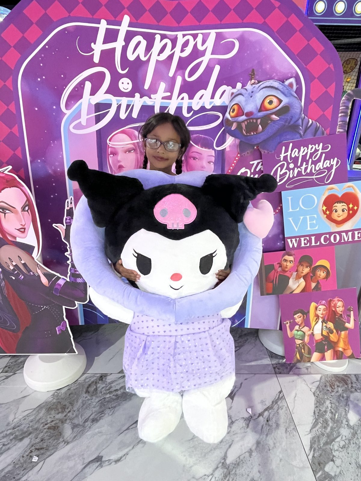 Costumed mascot at a birthday photo backdrop