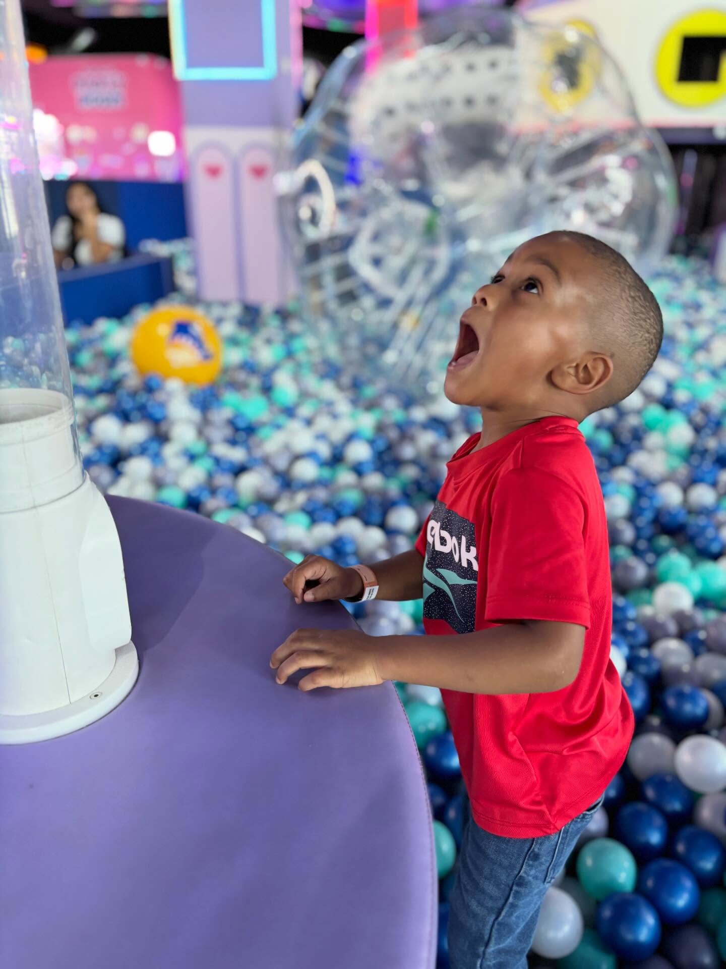 Boy laughing in the ball pit