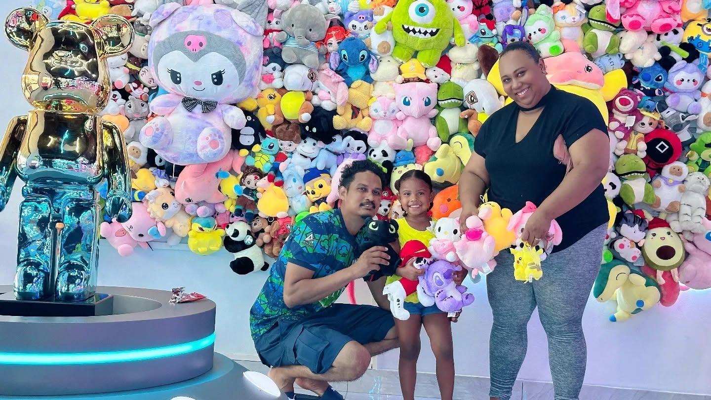 Happy family at the giant plushie prize wall