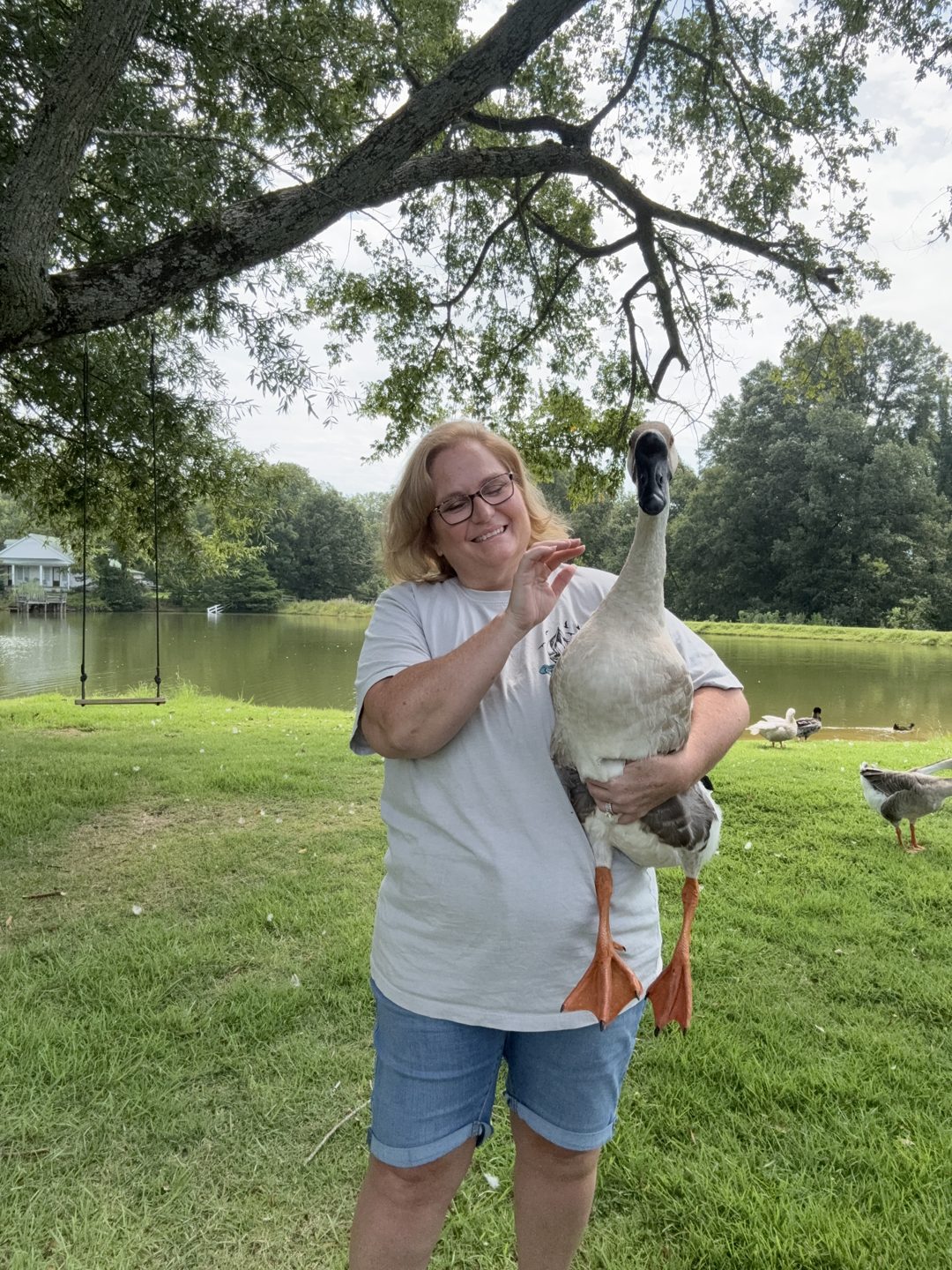 Kari Witt holding Duke the goose by the pond on her West Tennessee farm