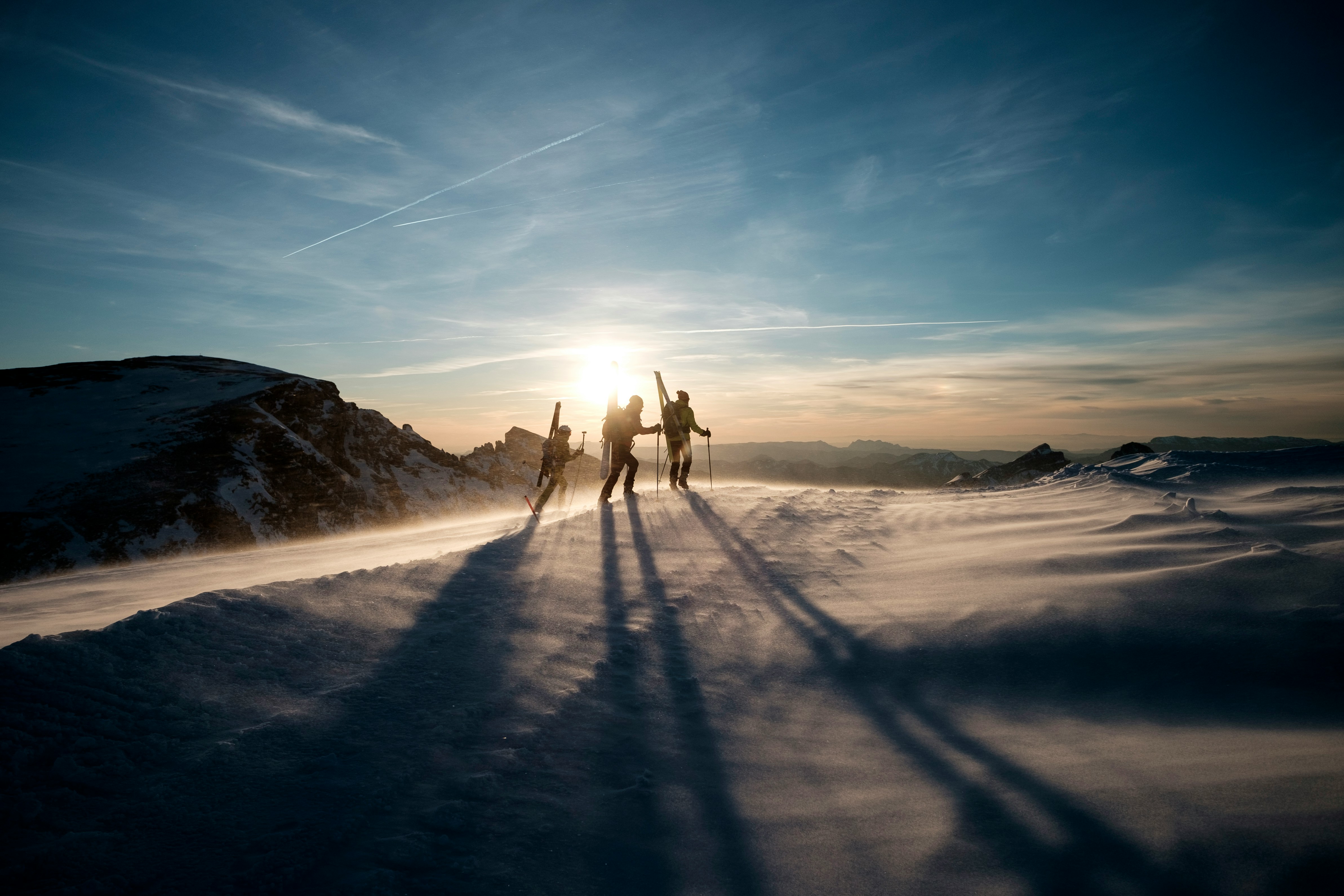 Caregiver skiing down sunlit mountain slopes