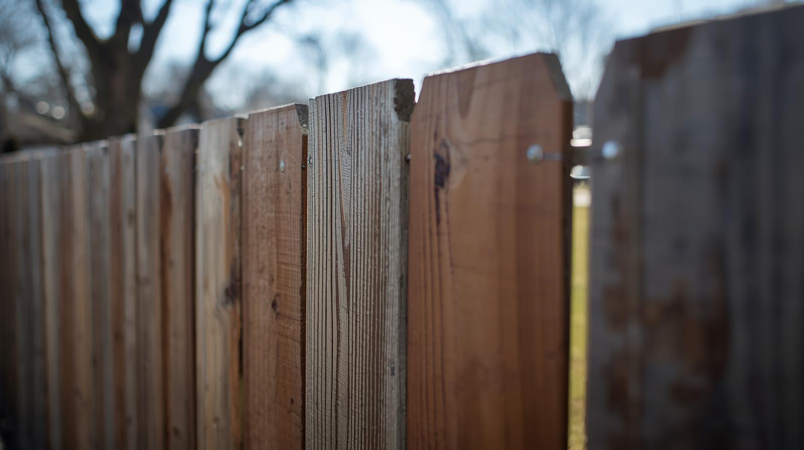 Fence repair service in Loves Park IL fixing damaged wood fence panels and leaning posts.