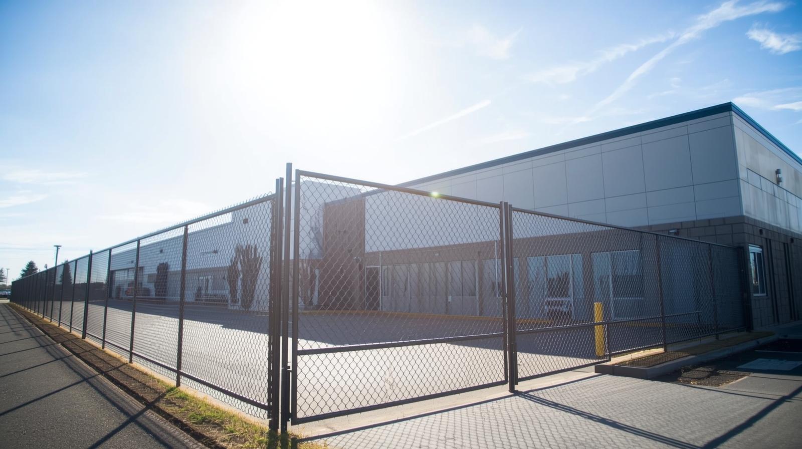 Commercial security fence installation around business property in Wisconsin with chain link and access gate.