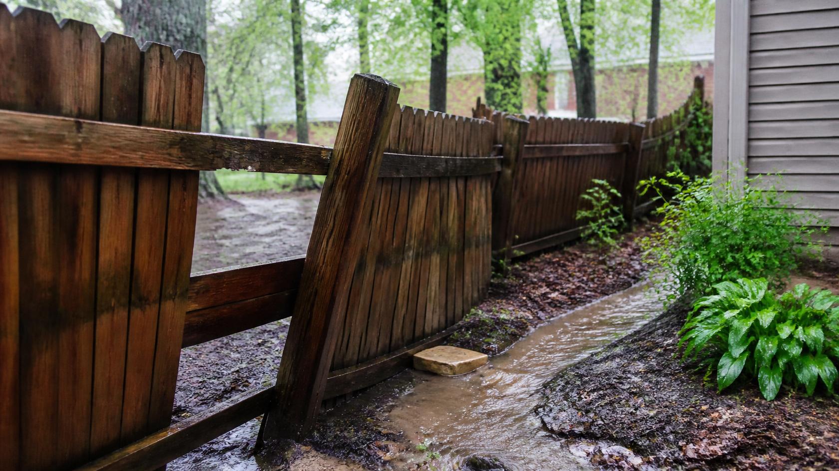 Fence in Galena, IL being inspected after heavy rain for damaged posts, shifted panels, drainage problems, and other repair needs.