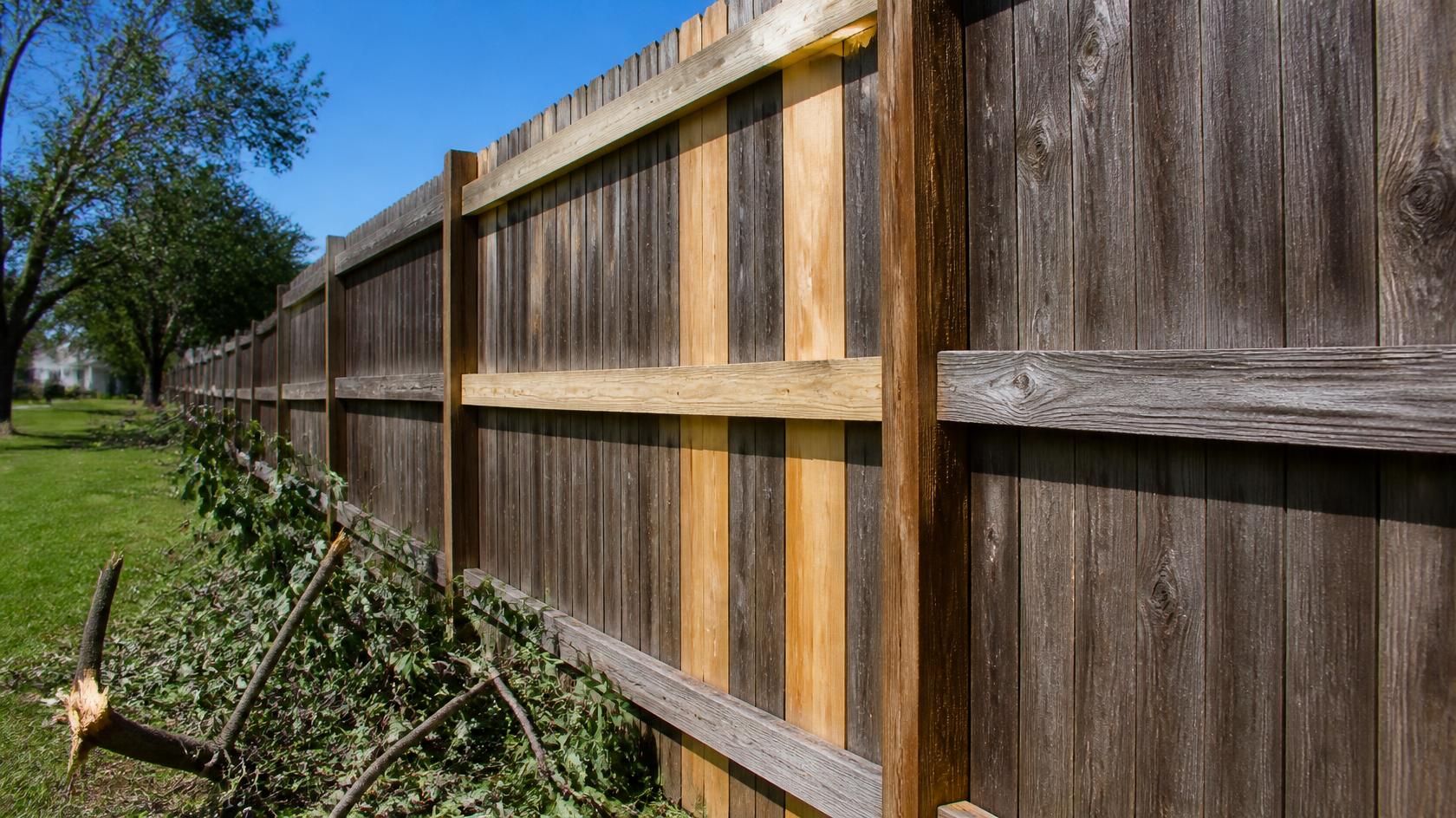 Residential fence in Sycamore, IL being inspected for wind damage, leaning posts, loose panels, broken boards, and gate problems.