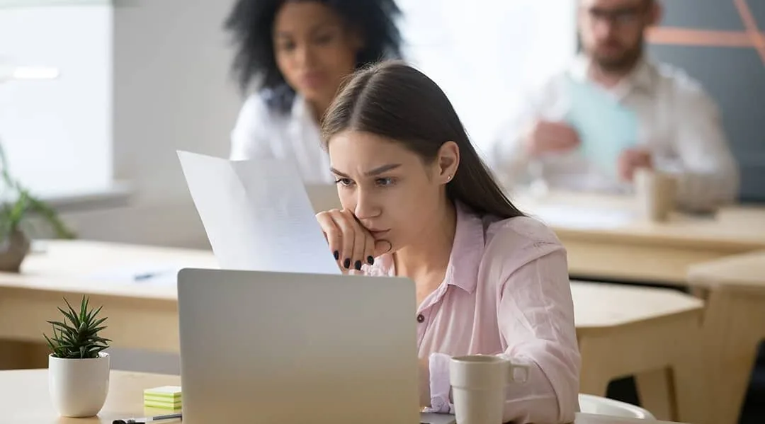 Employee reading a document at a laptop