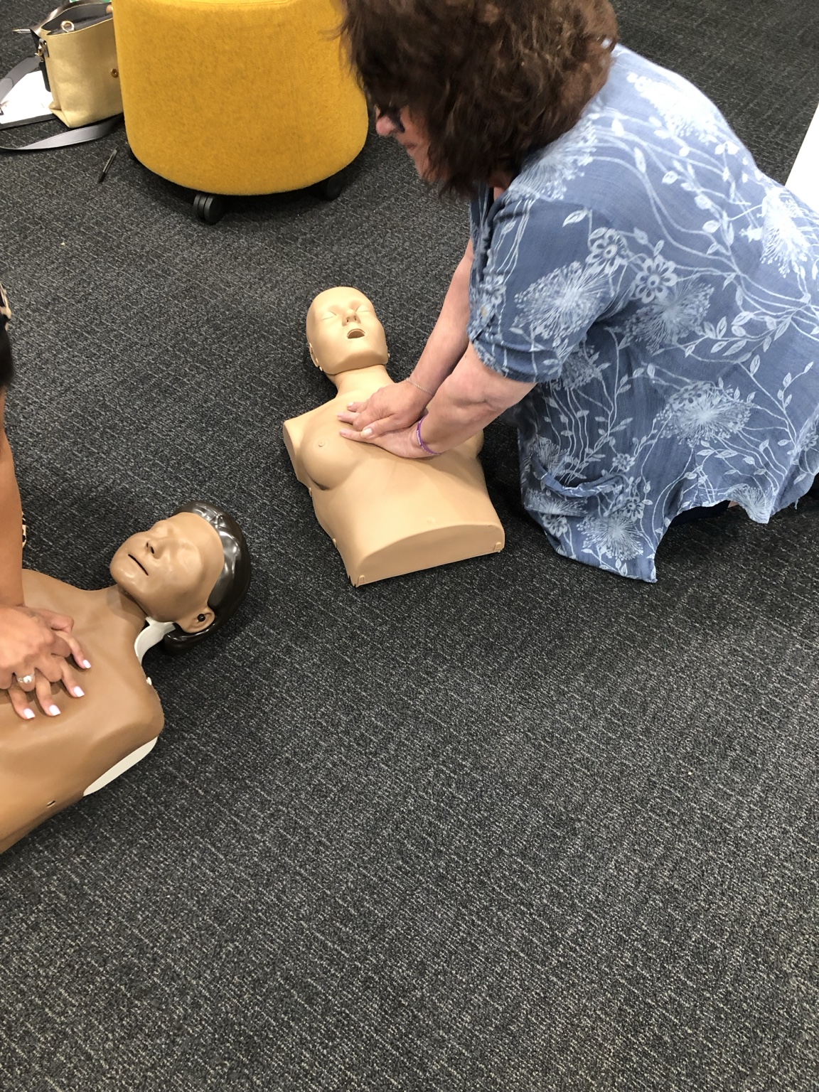 Practical first aid training using a training manikin on the floor