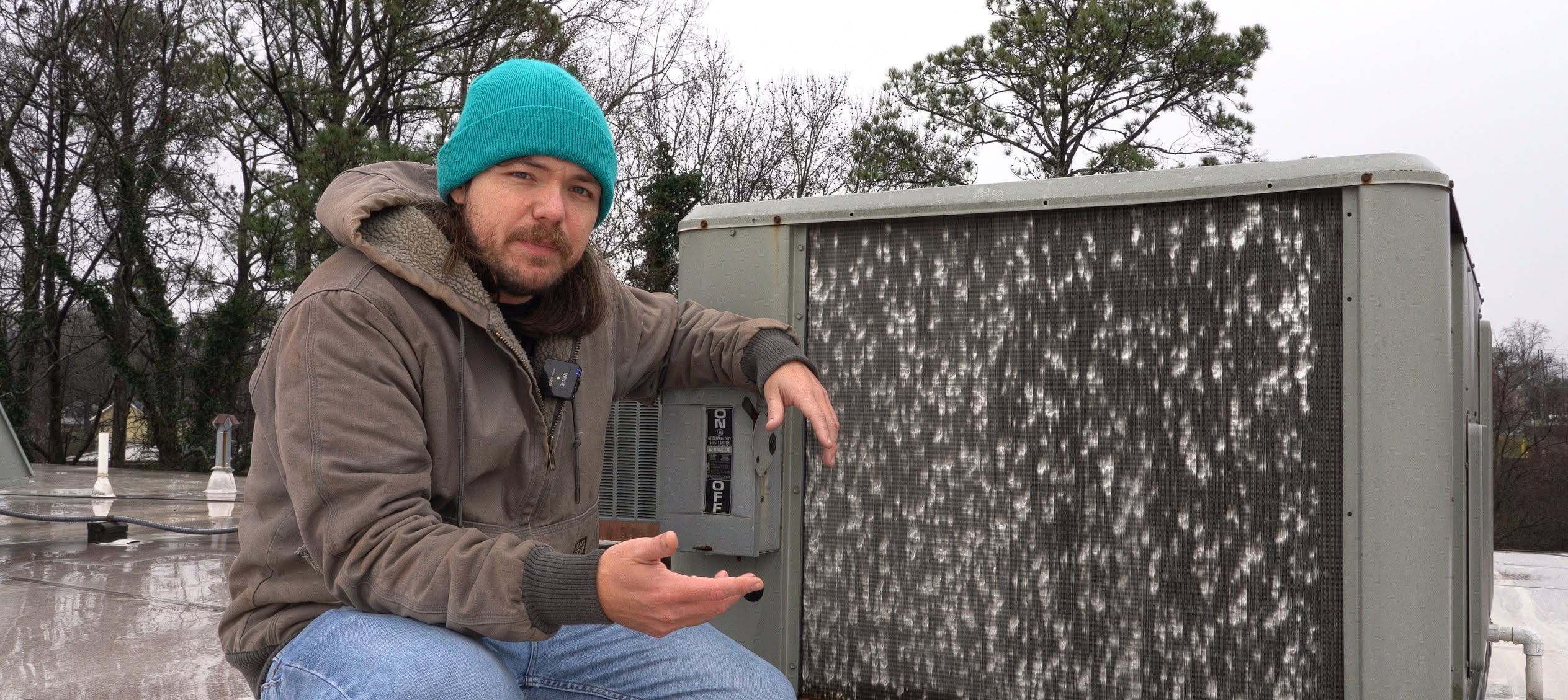 Joa Barron inspecting hail damage on rooftop equipment in winter