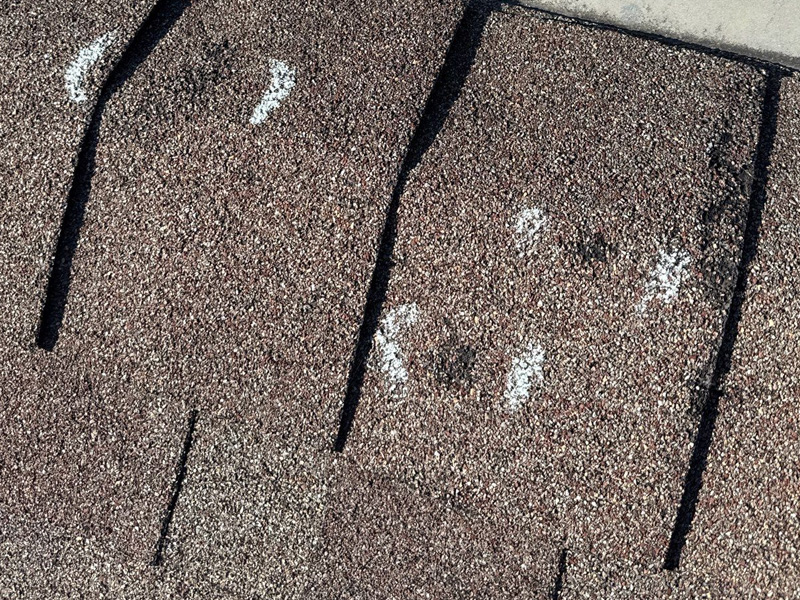 Hail impact marks with granule loss on asphalt shingles