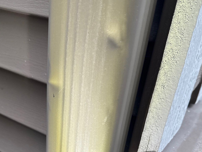 Hail dents on metal gutter