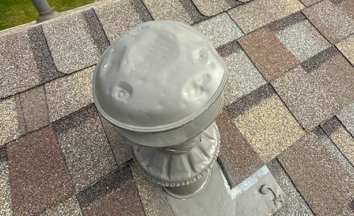 Hail damage dented vent cap on roof — Twin Cities storm damage inspection by Honest Exteriors