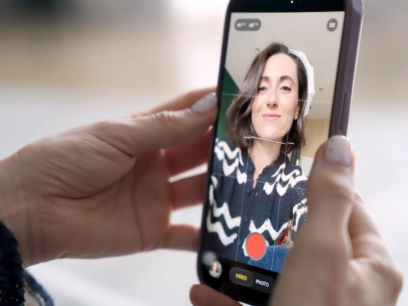 Hands holding iphone recording a video of Alex talking to screen