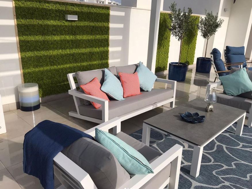 Terraza con pared de musgo artificial