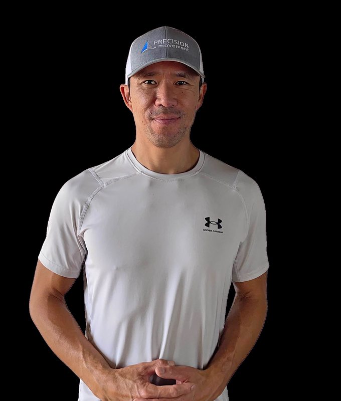 Eric Wong, Coach E, wearing a Precision Movement cap and smiling at the camera