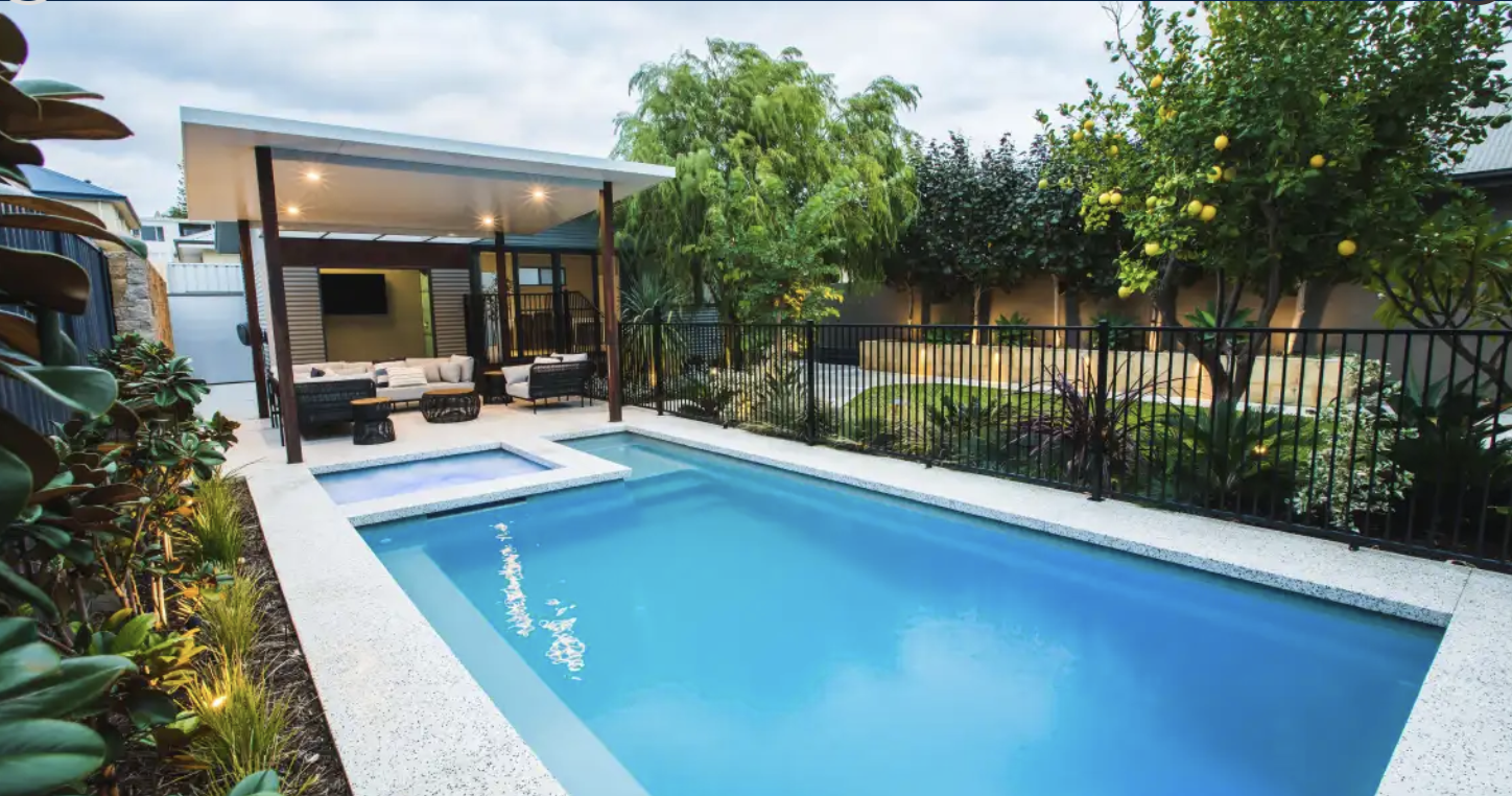 Landscaped backyard swimming pool with covered outdoor entertaining area