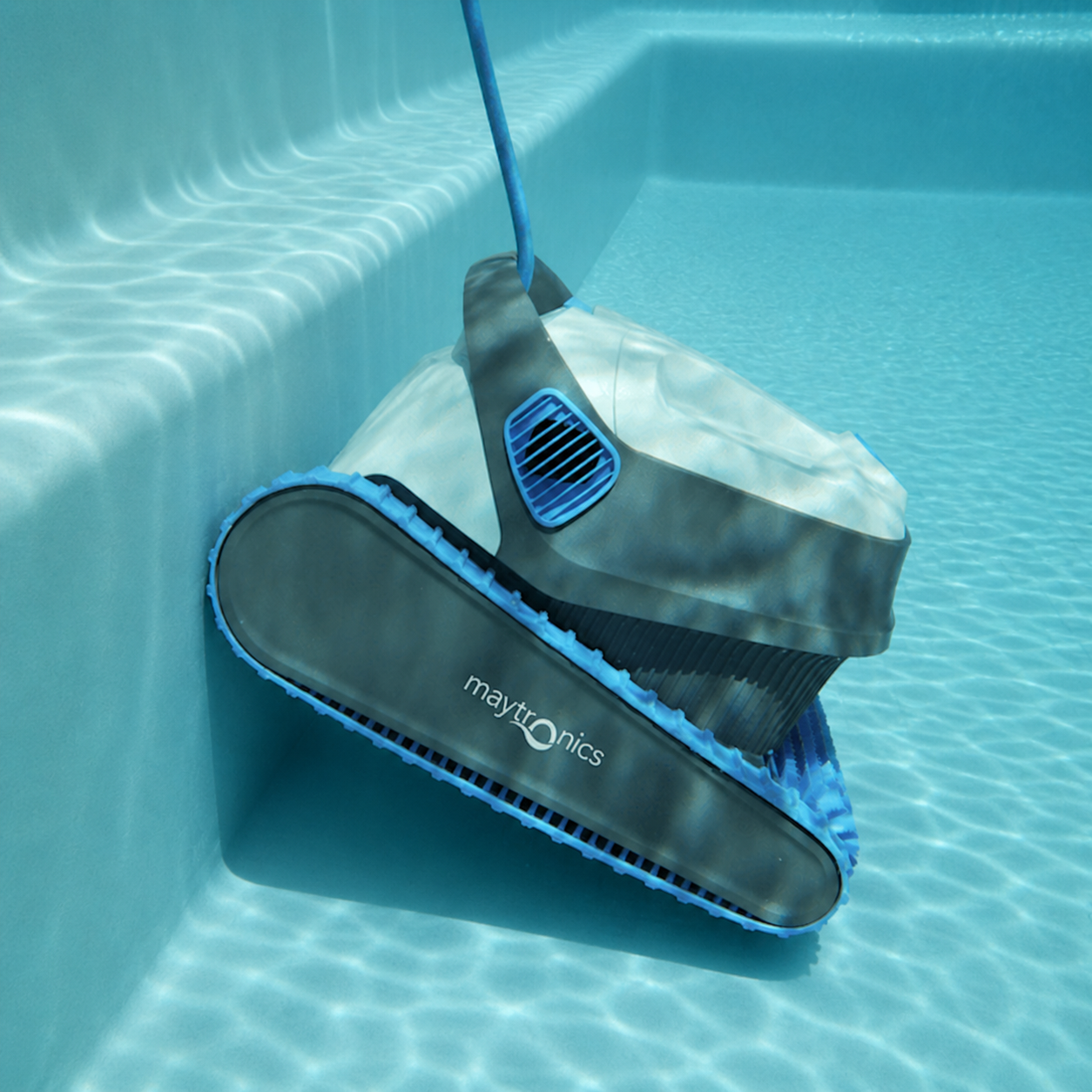 Maytronics robotic pool cleaner climbing the steps of a fibreglass swimming pool