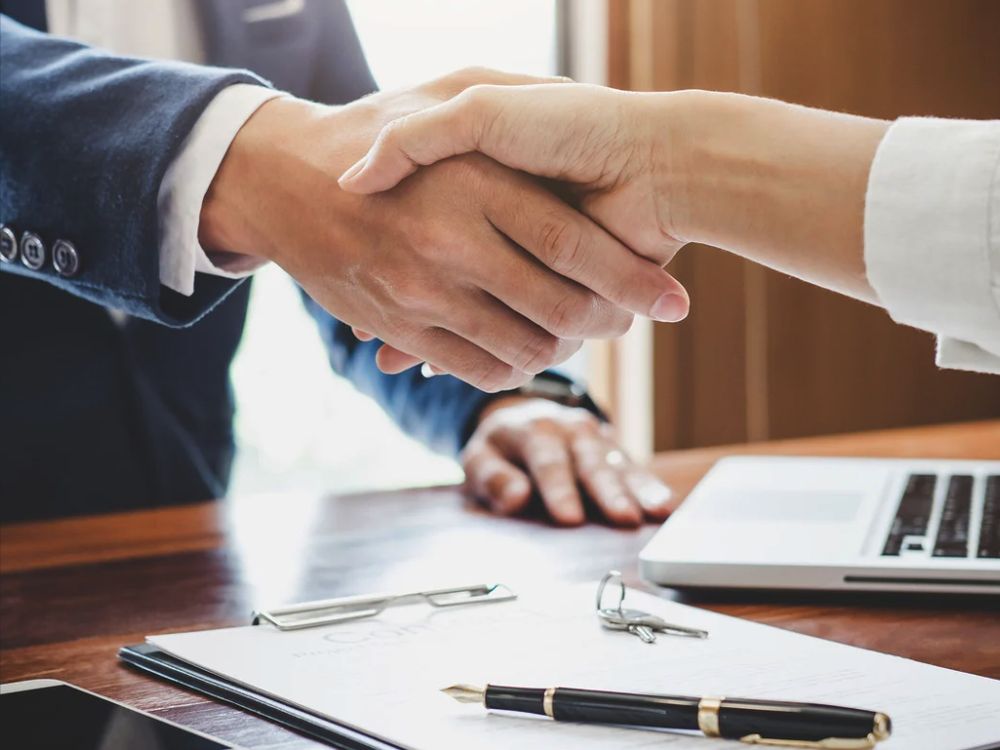 Shaking hands over a signed agreement