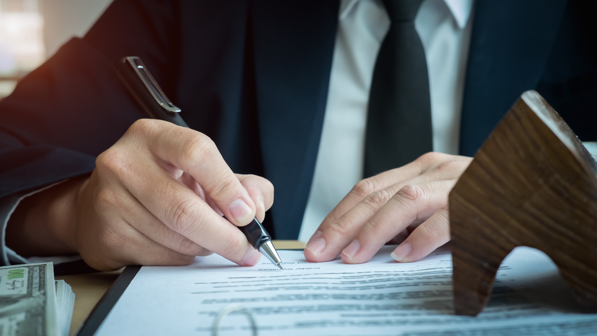 A man in a suit signing a contract