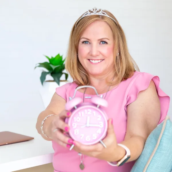 Marie holding a pink alarm clock