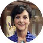 Professional woman in a blue jacket, smiling, with a decorative background, representing client satisfaction and success in business growth through effective marketing strategies.