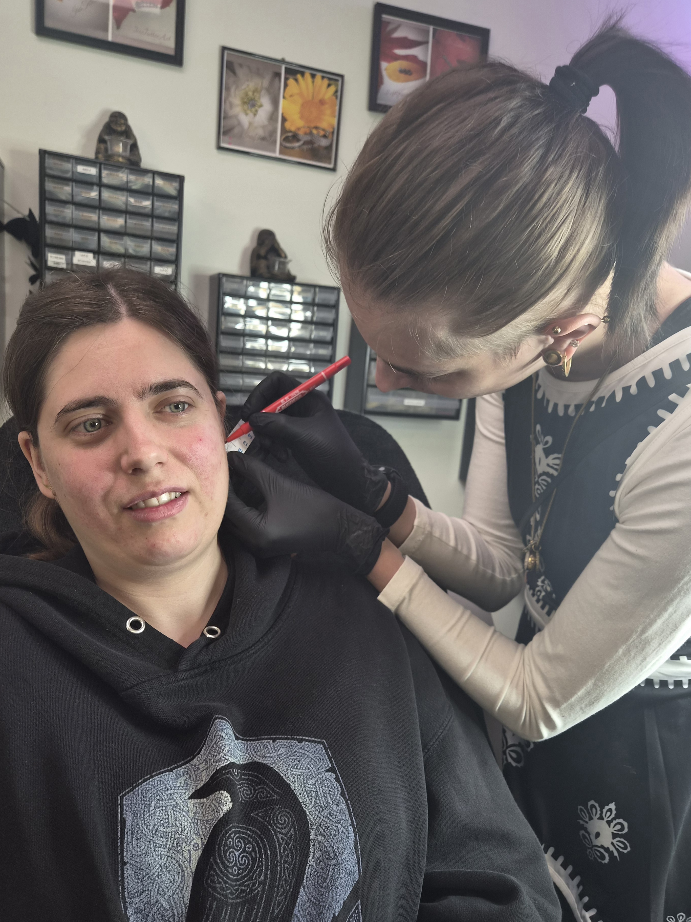 Piercing specialist Marja zet een oorbel piercing bij een klant in Iris Tattoo Art Deventer