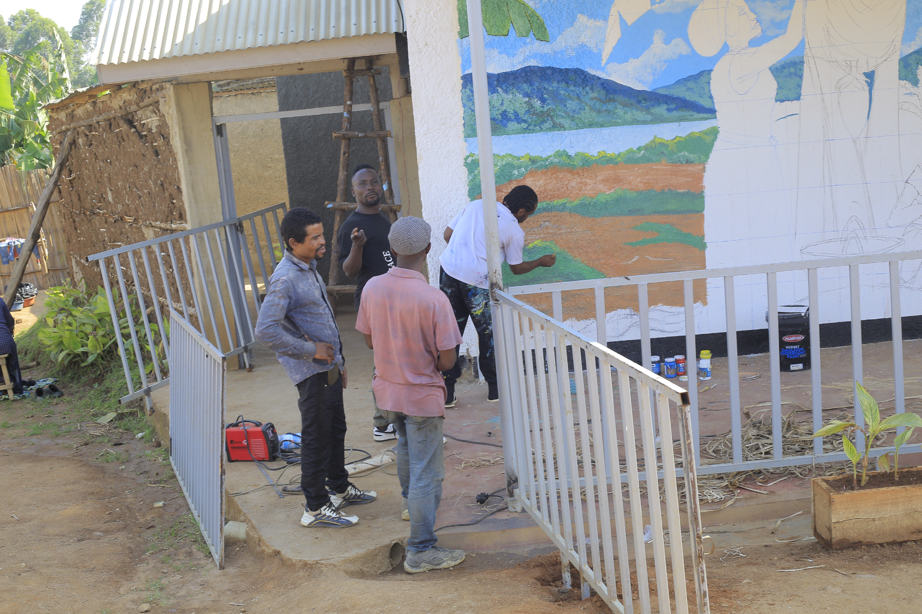 Artists paint a mural on the Creative Center