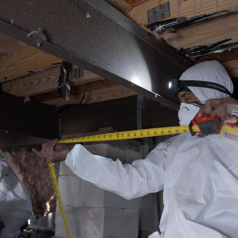 A technician from Vapor Barrier Bradenton installing a new, thick white vapor barrier under a mobile home in Bradenton, FL.