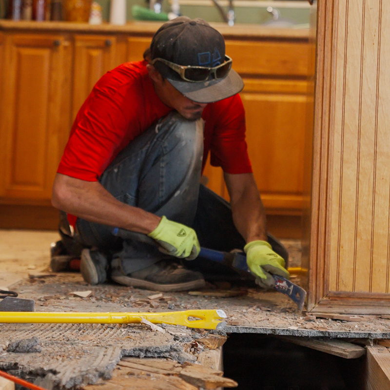 The underbelly of a mobile home in Palm Harbor, Florida, being sealed with a new ground moisture barrier to prevent rot and pests.