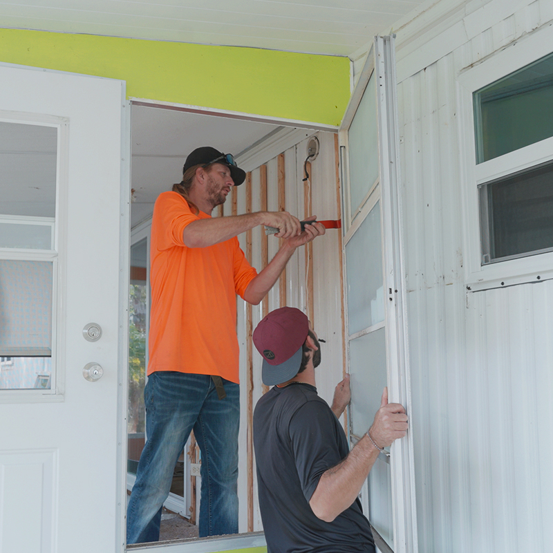 A professional from our team carefully sealing the seams of a new vapor barrier installation in a Palm Harbor mobile home.
