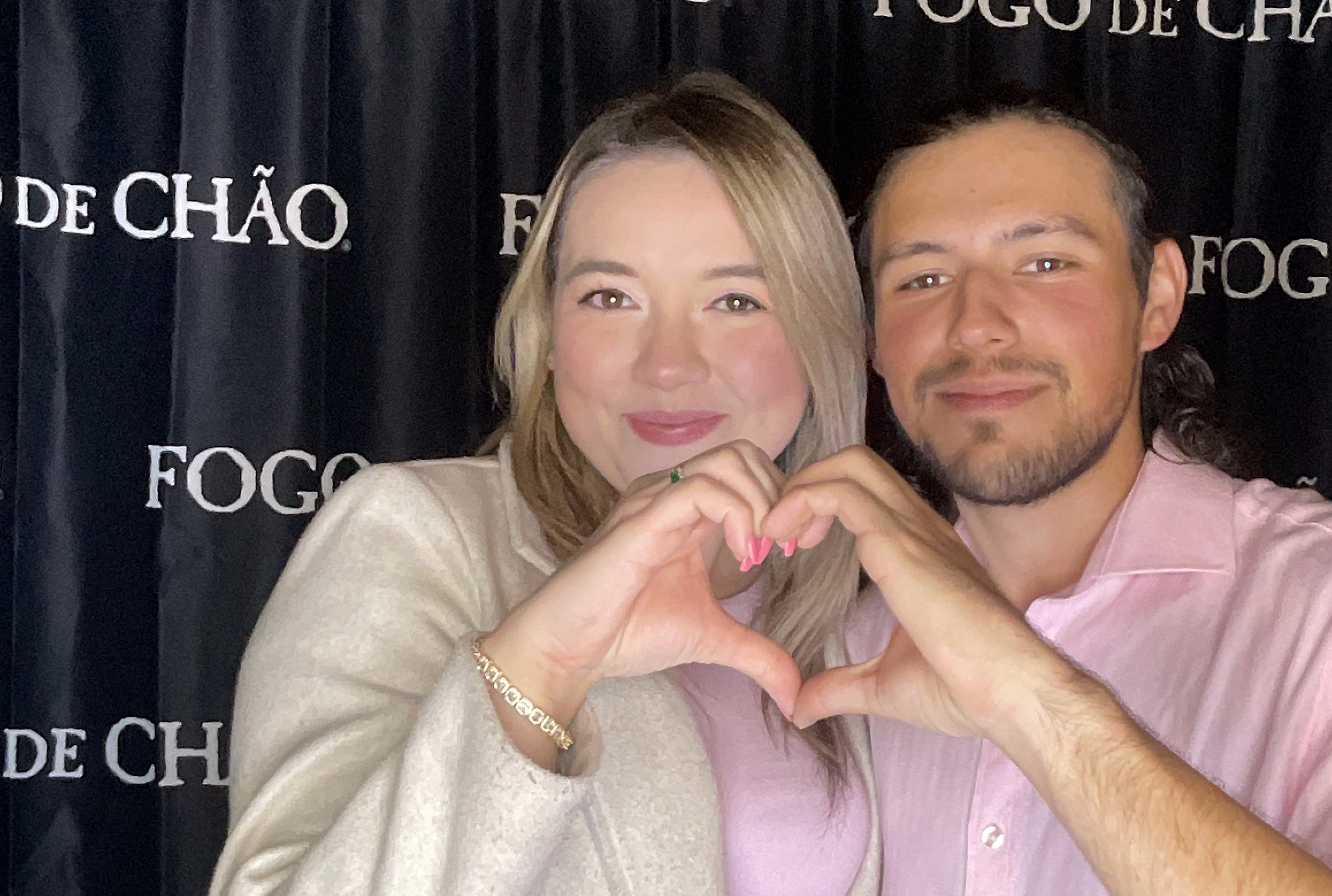 Guests making a heart pose at the Fogo de Chão Brea Valentine’s Day 2026 photo booth