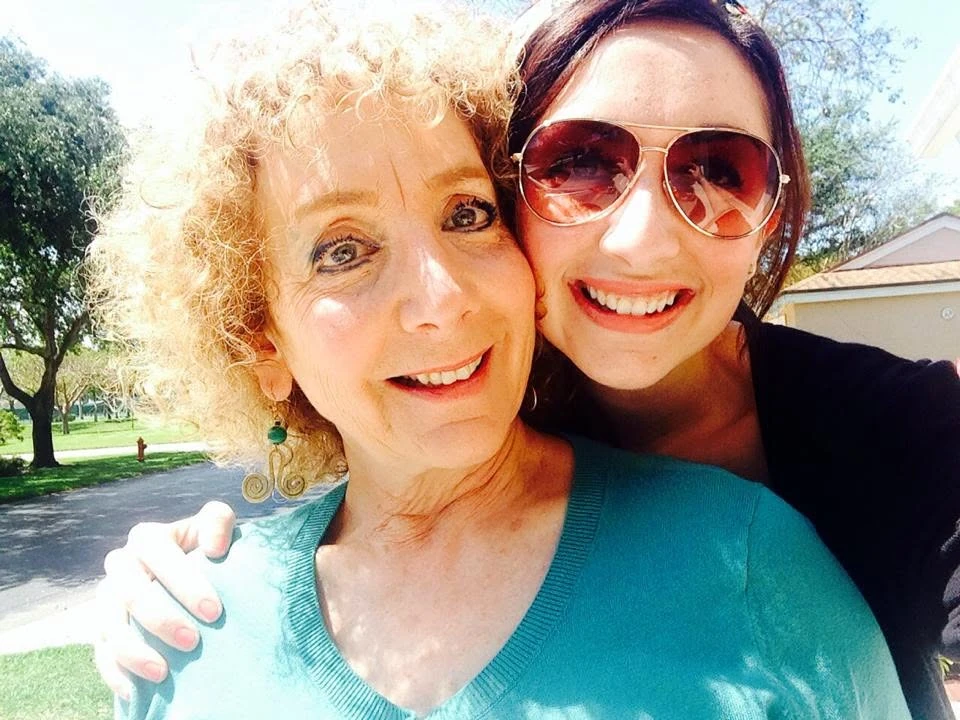 Sandra B. Dreis with her daughter, Haley, smiling together outdoors.
