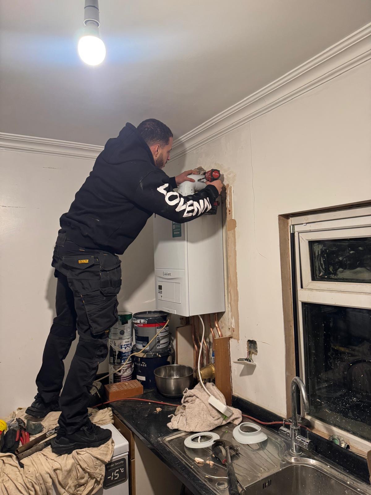 Gas Safe heating engineer working on a boiler