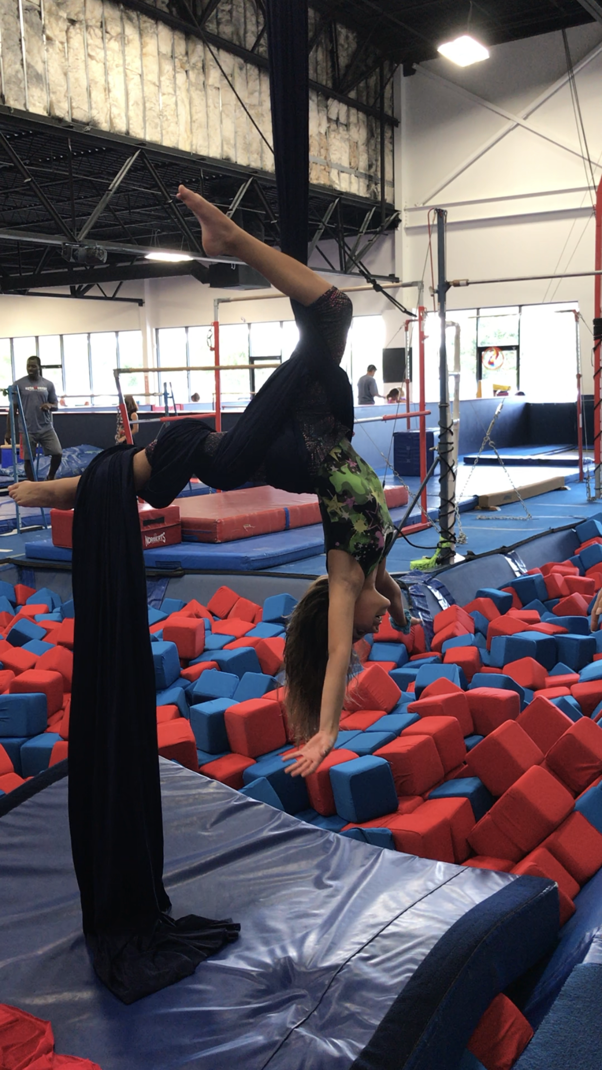 Student practicing aerial acrobatics at Alpha Omega