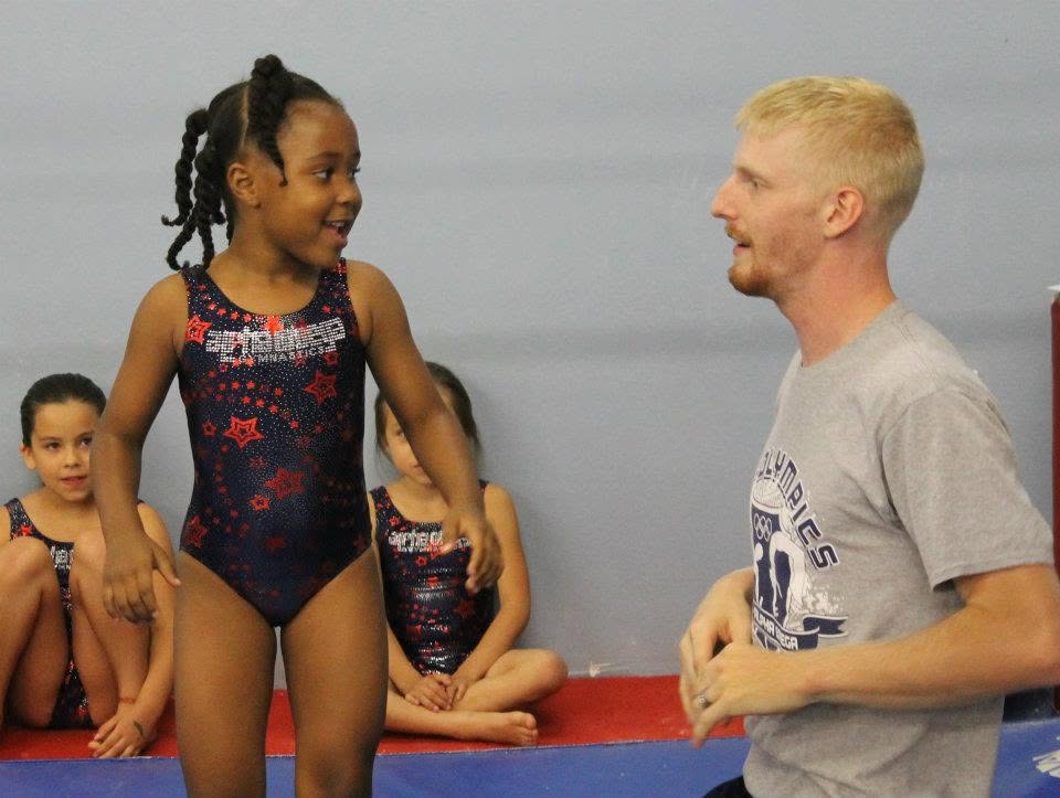 Coach working 1-on-1 with a gymnast during a private lesson
