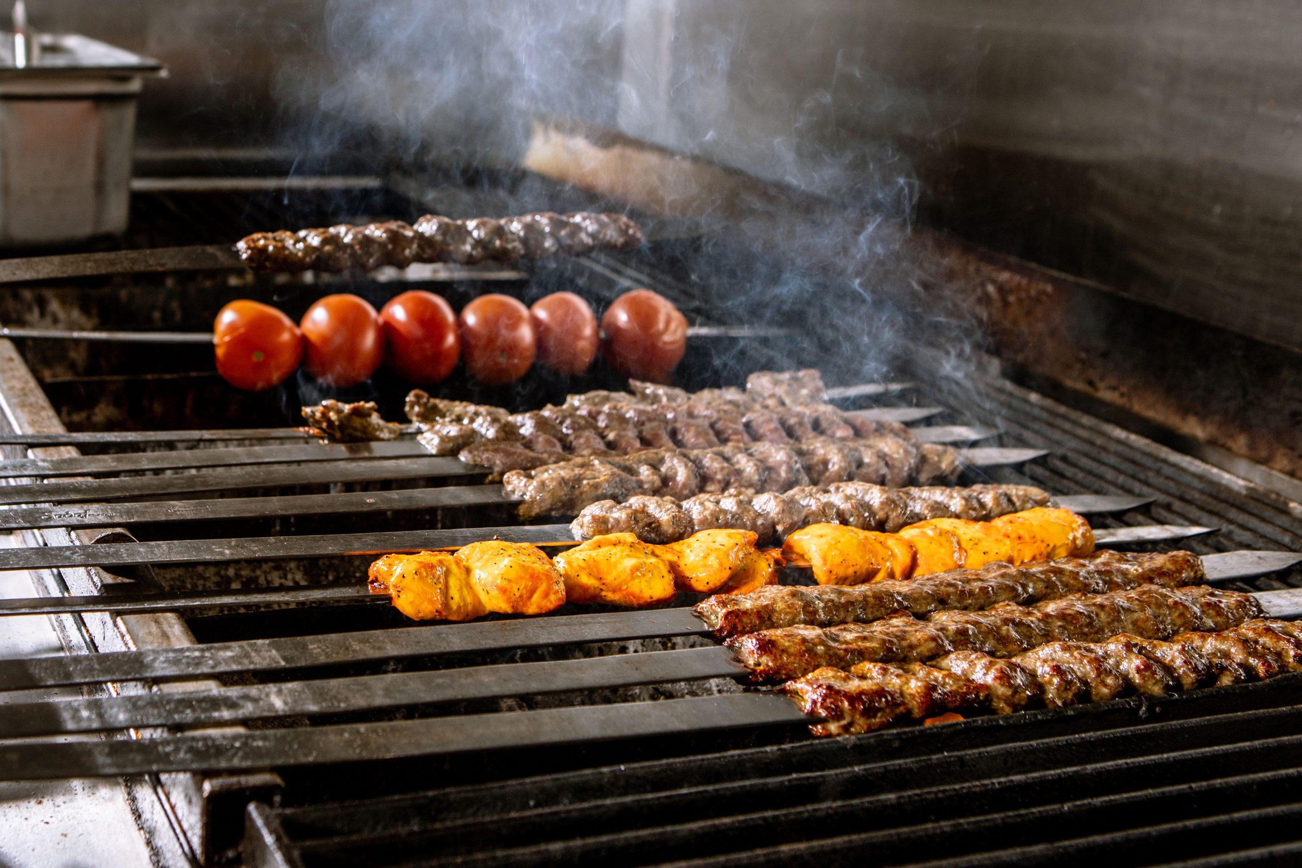 Assorted Persian kabobs — koobideh and saffron chicken — flame-grilled over charcoal at Chop Kabob in Westborough, Massachusetts