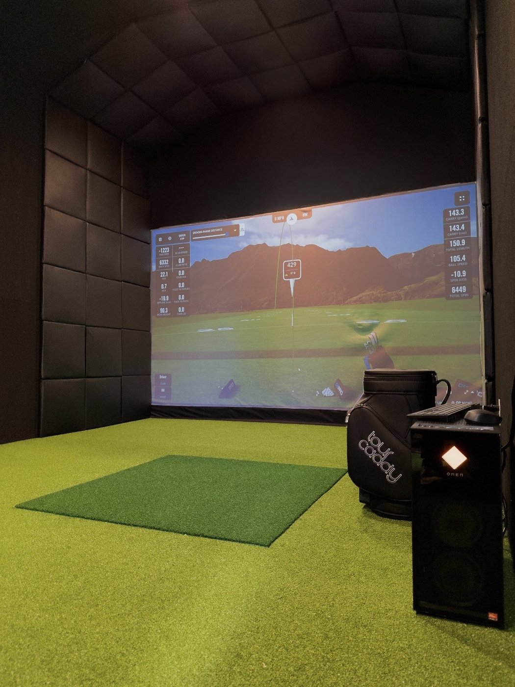 Inside the same shed, padded walls and turf with a golf course live on the impact screen.