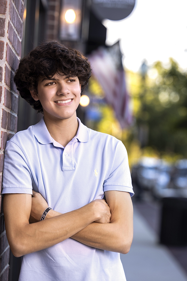 Senior boy in a gray polo shirt leaning beside a brick wall. Senior boy in a gray polo shirt leaning beside a brick wall.