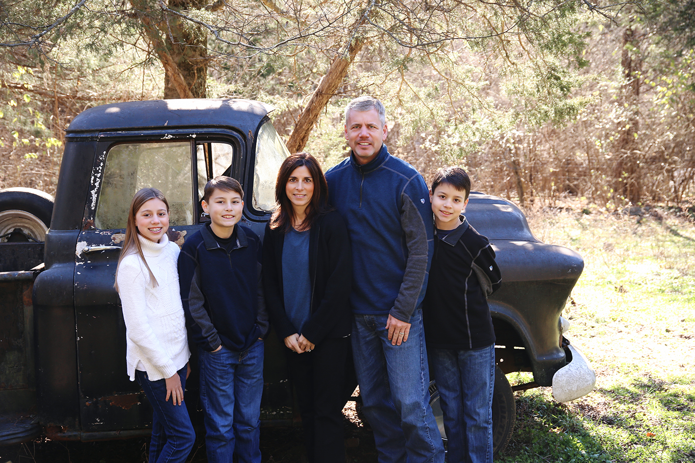 Williams parents and three children standing beside a vintage car. Williams parents and three children standing beside a vintage car.