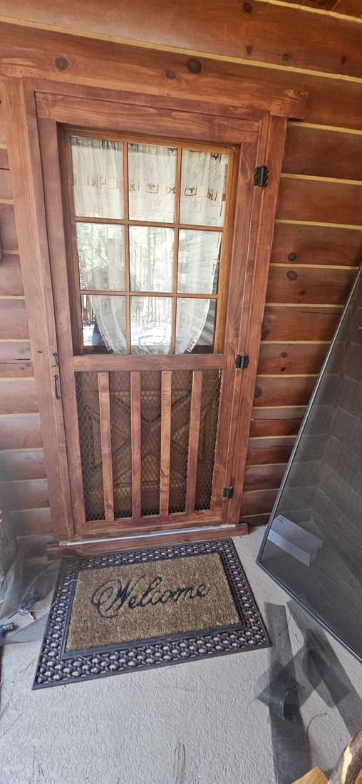 Wood screen door at a front entry after service