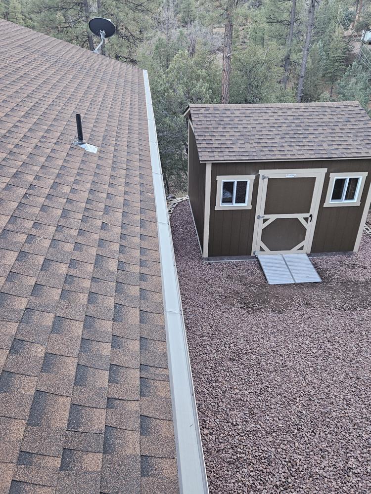 Finished gutter guard on a roof edge next to a shed