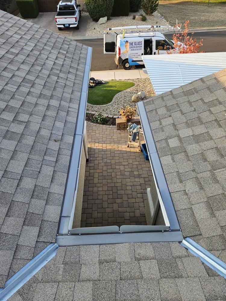Gutter guard on both sides of a roof valley with the company van below