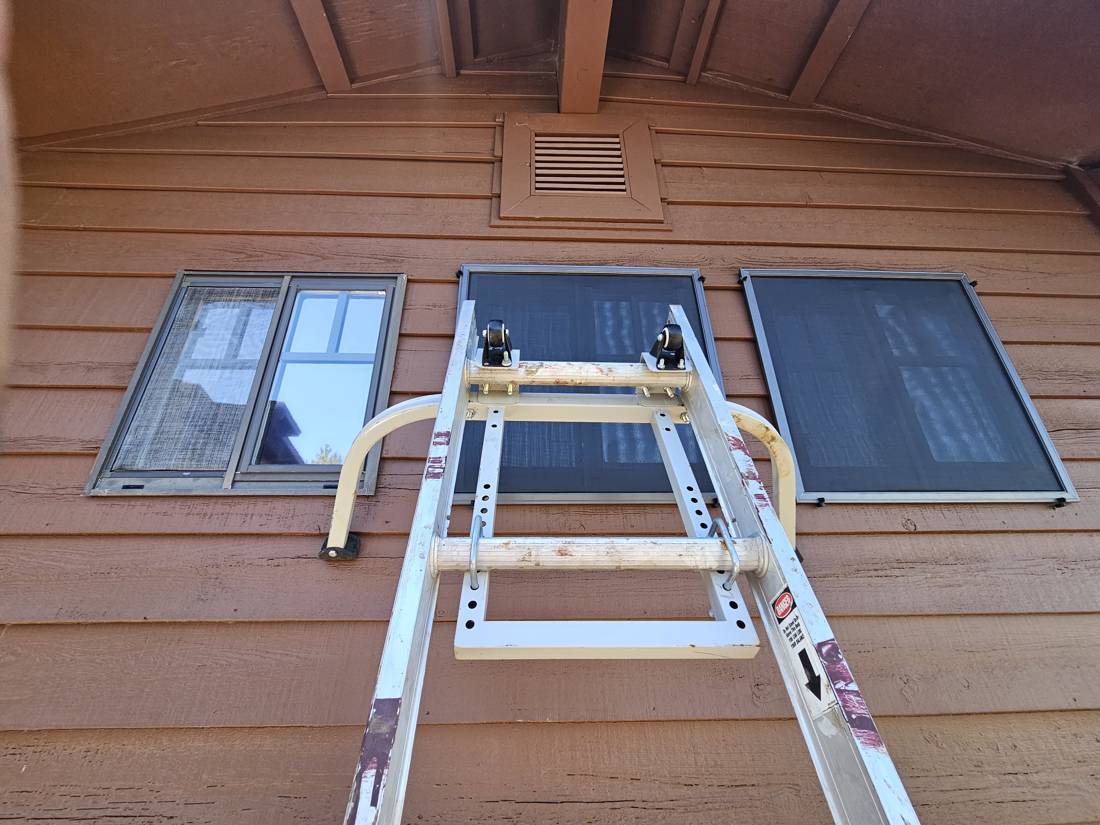 Two windows with new overlapping solar screens next to one with an old worn bug screen