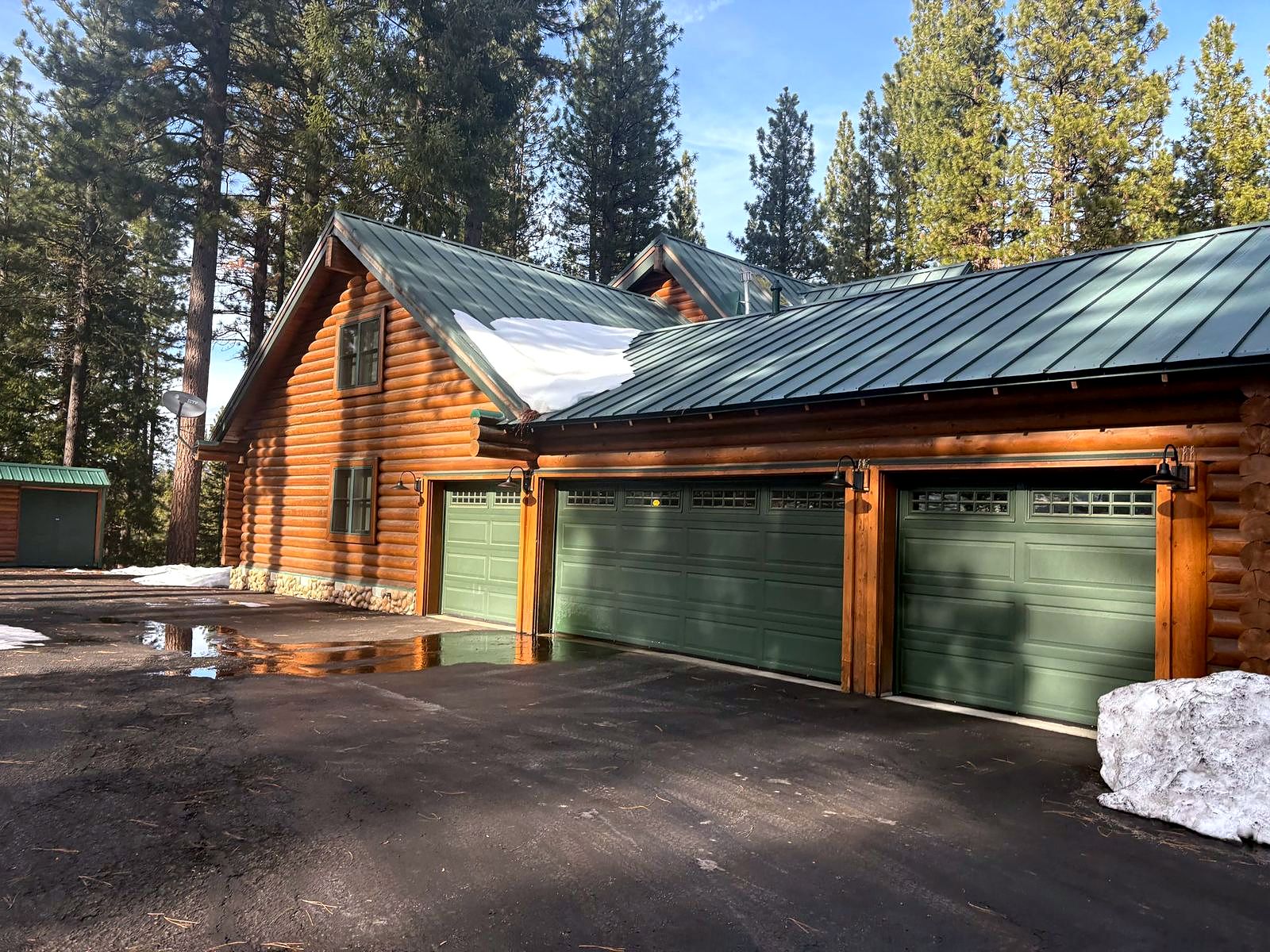 Restored log home with a green metal roof