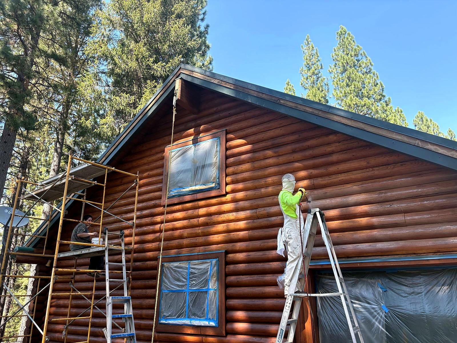 Crew member on a ladder with the windows masked off